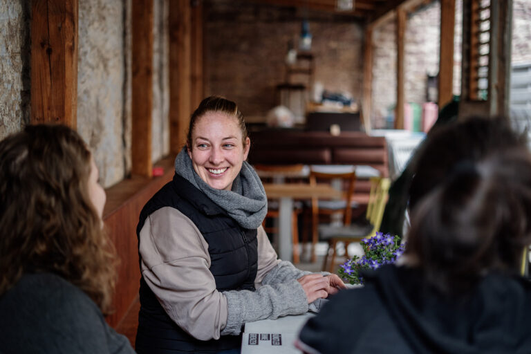lachende Frau sitzt an einem Tisch