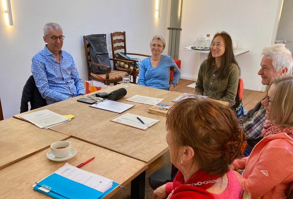 Menschen sitzen um einen großen Tisch